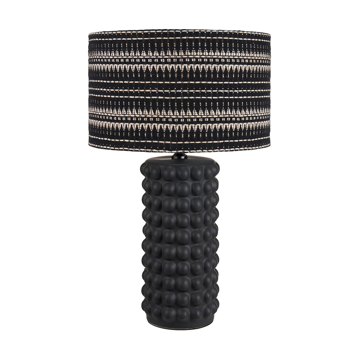 Sohan Black Bobbled Ceramic Tall Table Lamp Base with a textured cylindrical body and drum lamp shade in black and cream patterned fabric, shown on a plain white background.