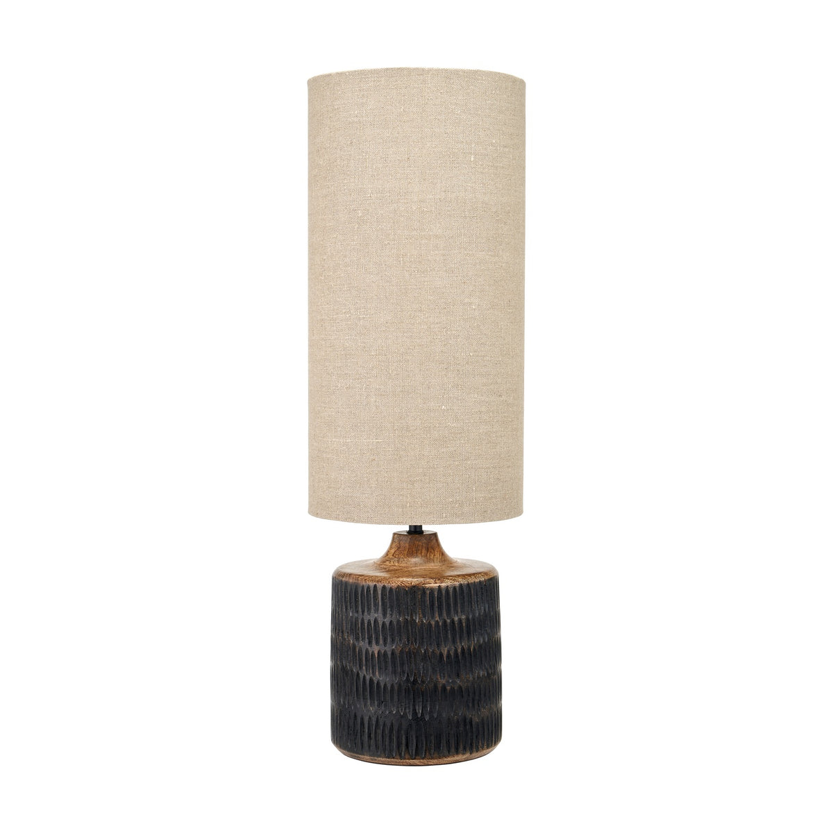 Alaric table lamp with a carved antique black wash mango wood base and tall cylindrical natural linen shade, shown on a plain white background.