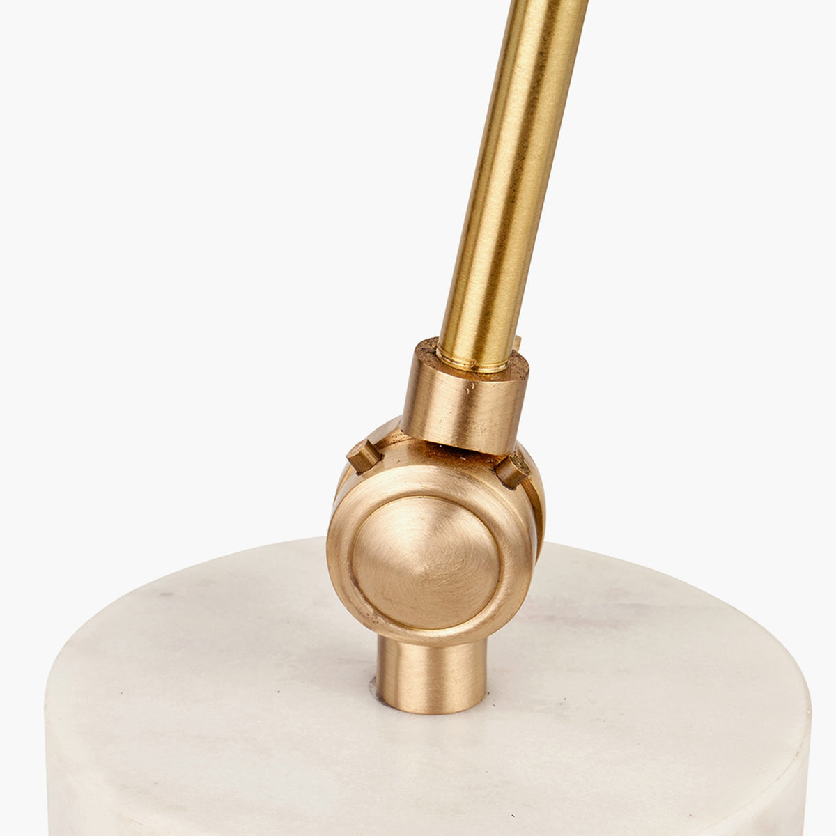 Close-up of the Eloise Gold Brass & Marble Table Lamp showing a brass ball joint and angled stem on a white marble base, plain background.