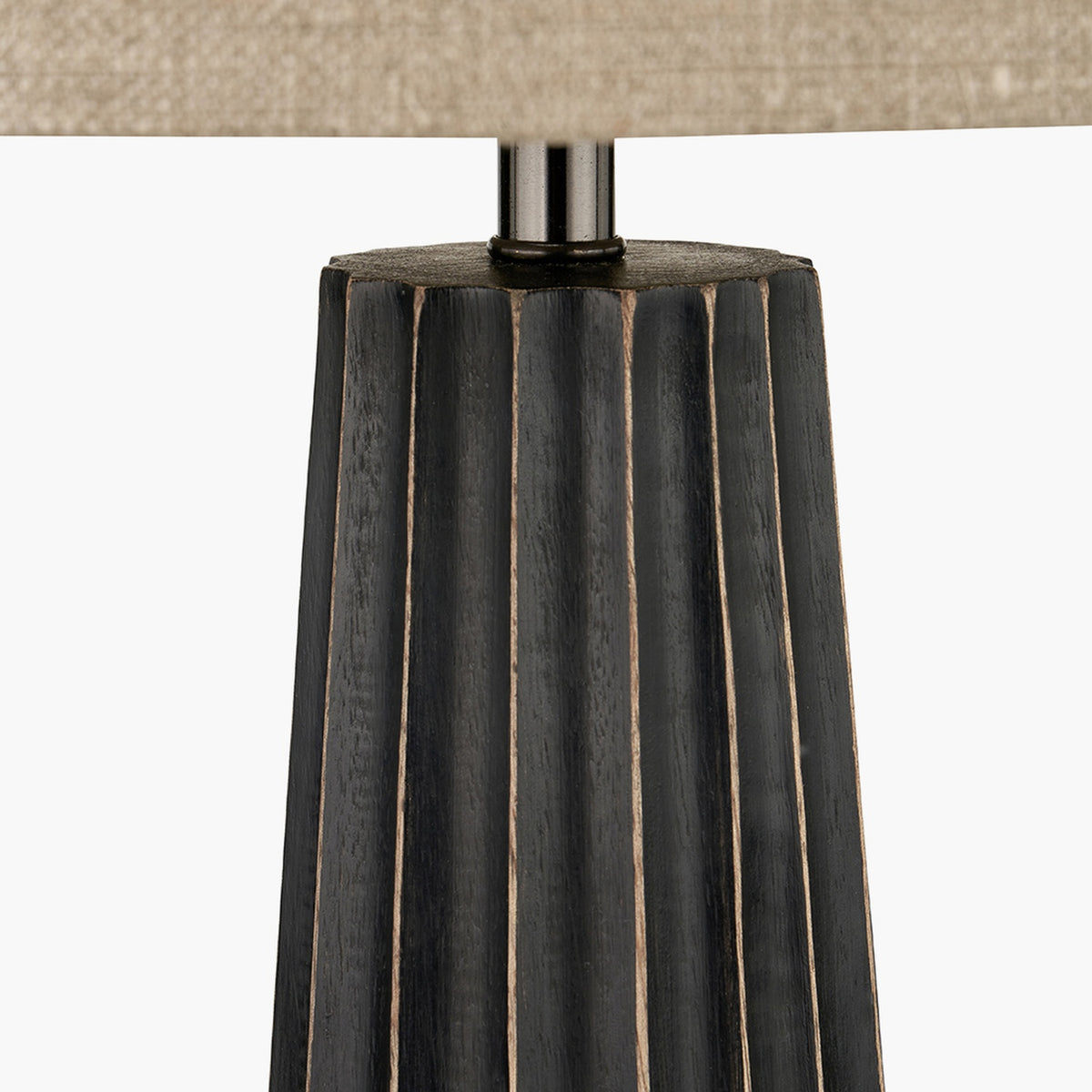 Close-up of the Draydon Black Wash Mango Textured Cone Table Lamp base, showing ridged black wood detailing beneath a linen shade on a plain background.