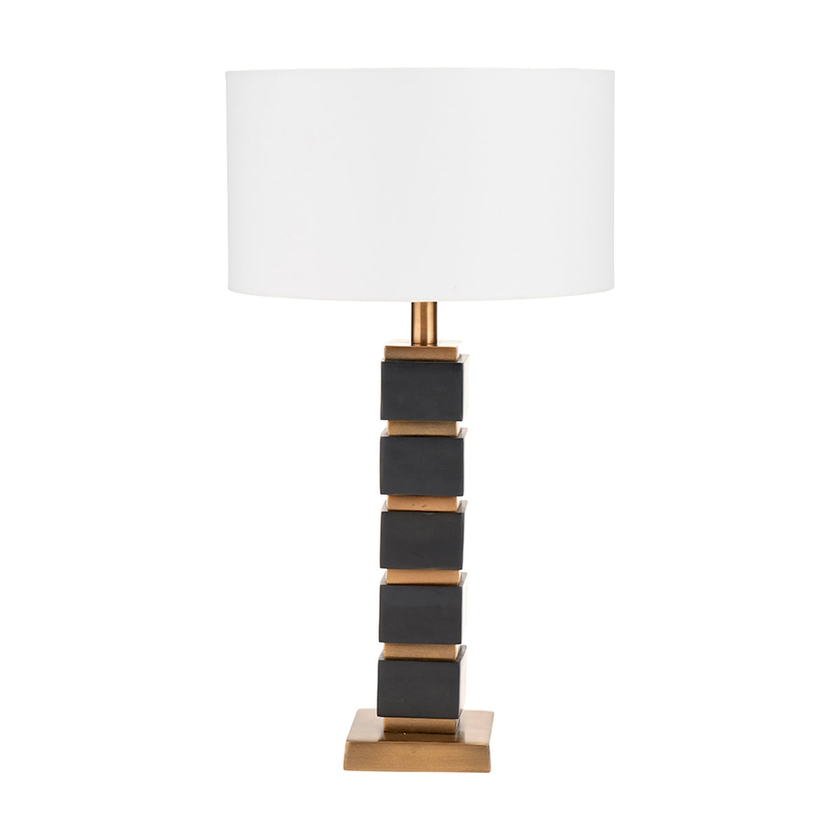 Maximo table lamp with white drum shade on a stacked cube base in matt black and antique brass finish, shown on a plain white background.