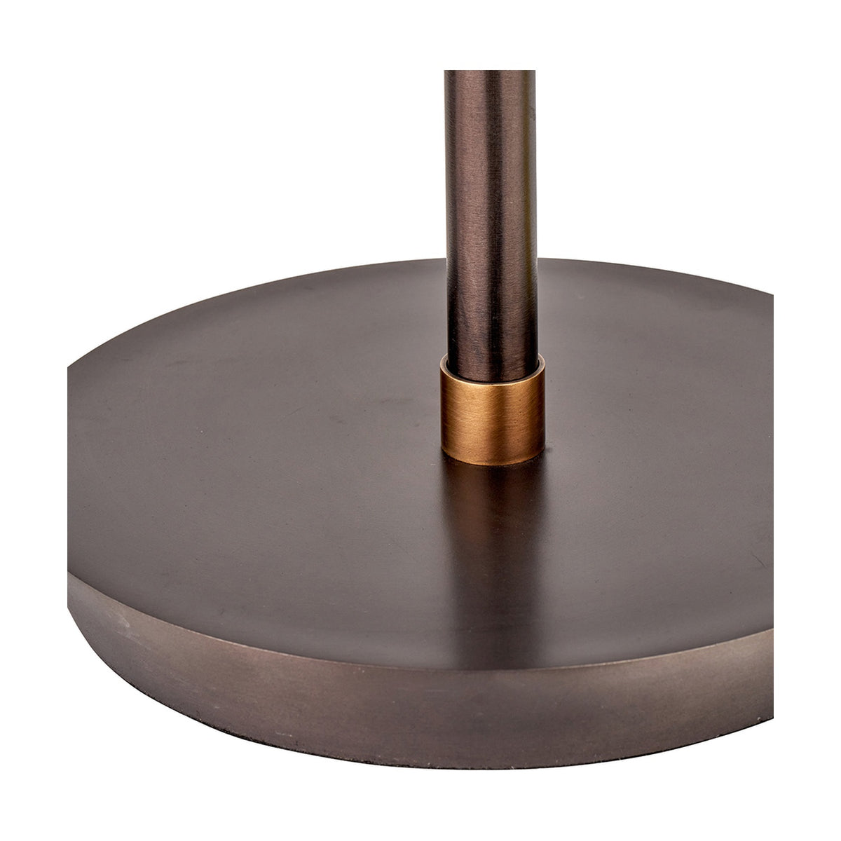 Close-up of the Emiliano table lamp's round antique bronze base and rod, joined by a brushed brass collar, on a plain white background.