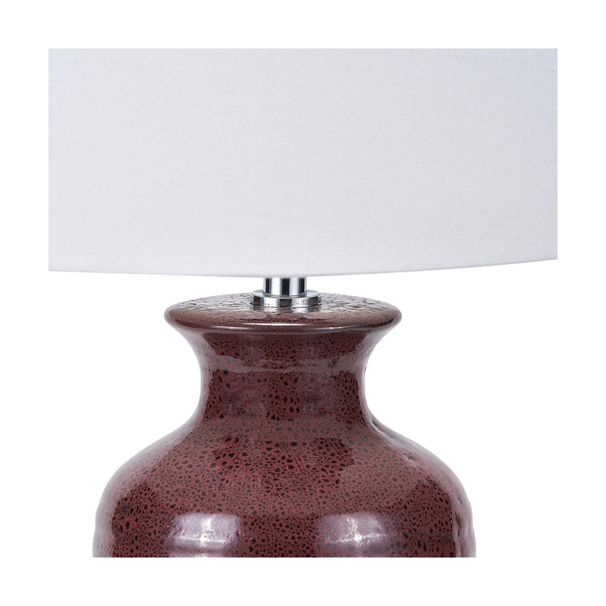 Close-up of the Helka Mulberry Red Reactive Glaze Table Lamp, showing the speckled ceramic base with chrome fitting beneath a white fabric drum shade, against a plain background.