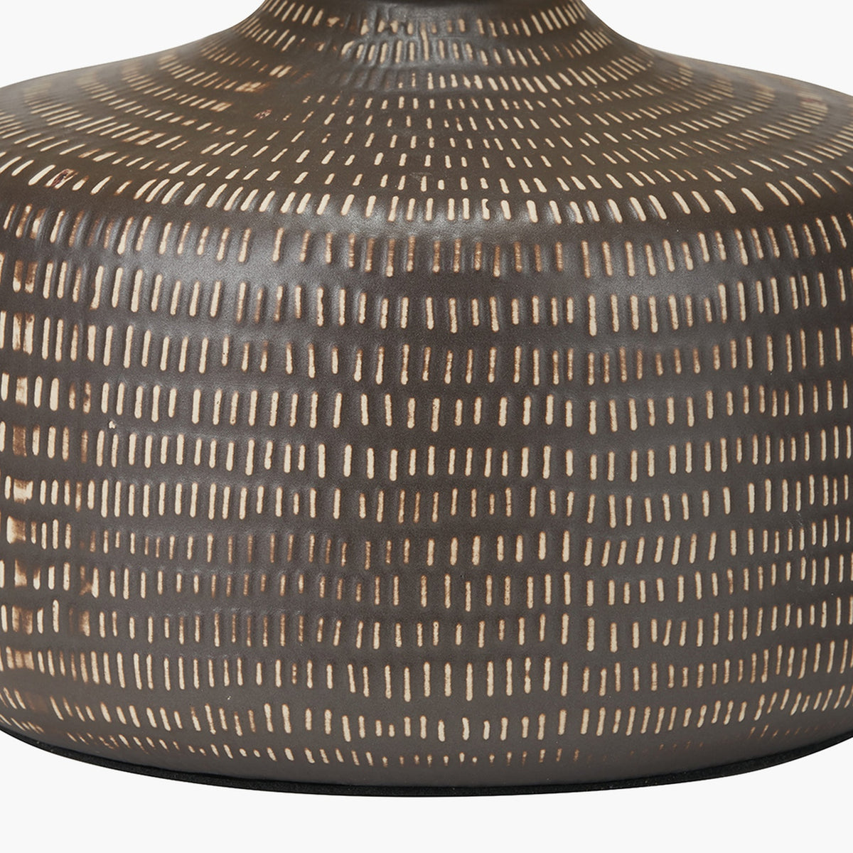 Close-up of the Kai Earth Brown Textured Ceramic Table Lamp base, showing a dotted dash pattern in cream on a matte brown ceramic surface.