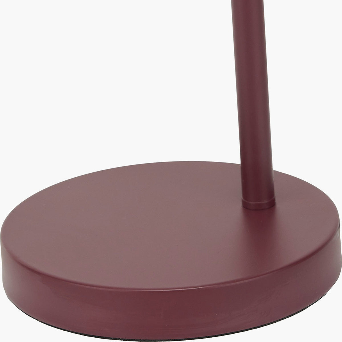 Close-up of the Finn Mulberry Red Metal Cloche Headed Table Lamp's round weighted base and slender metal stem in a matte mulberry finish, shown against a plain white background.
