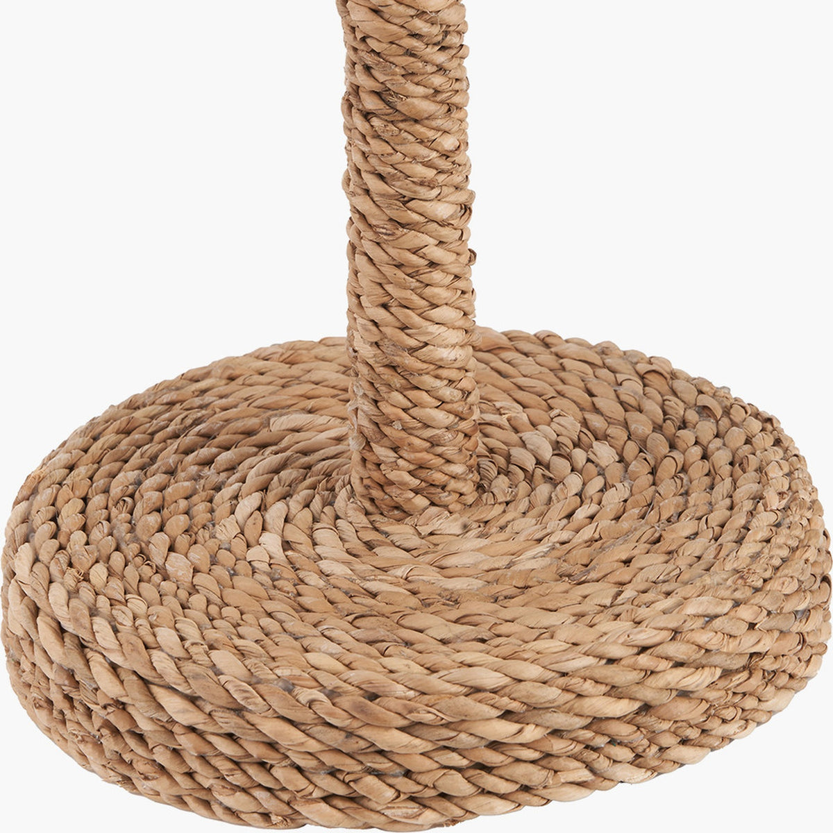 Close-up of the Leif Jute Rope Table Lamp base, showing tightly coiled natural rattan wrapped around a round base and cylindrical stem in a warm brown finish.