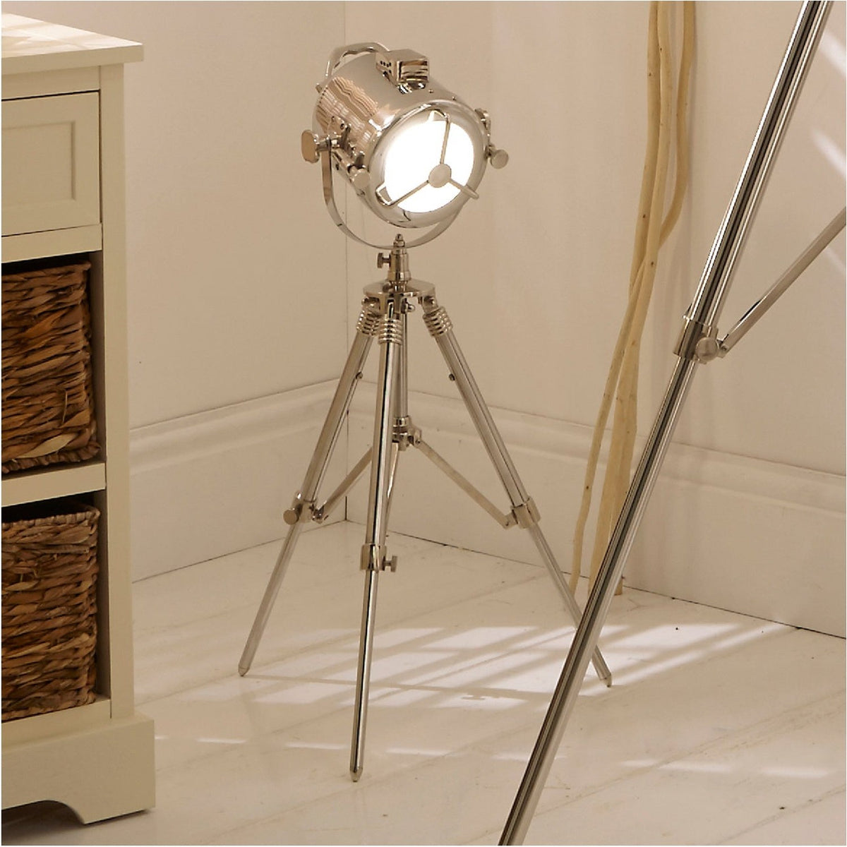 Marine Nickel Silver Searchlight Table Lamp, 67cm, on tripod stand with round spotlight-style shade, shown in a living room beside cream furniture and woven baskets.