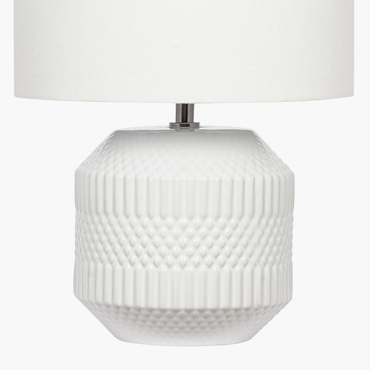 Meribel white ceramic table lamp with geometric textured base and cylindrical white fabric shade, shown against a plain white background.