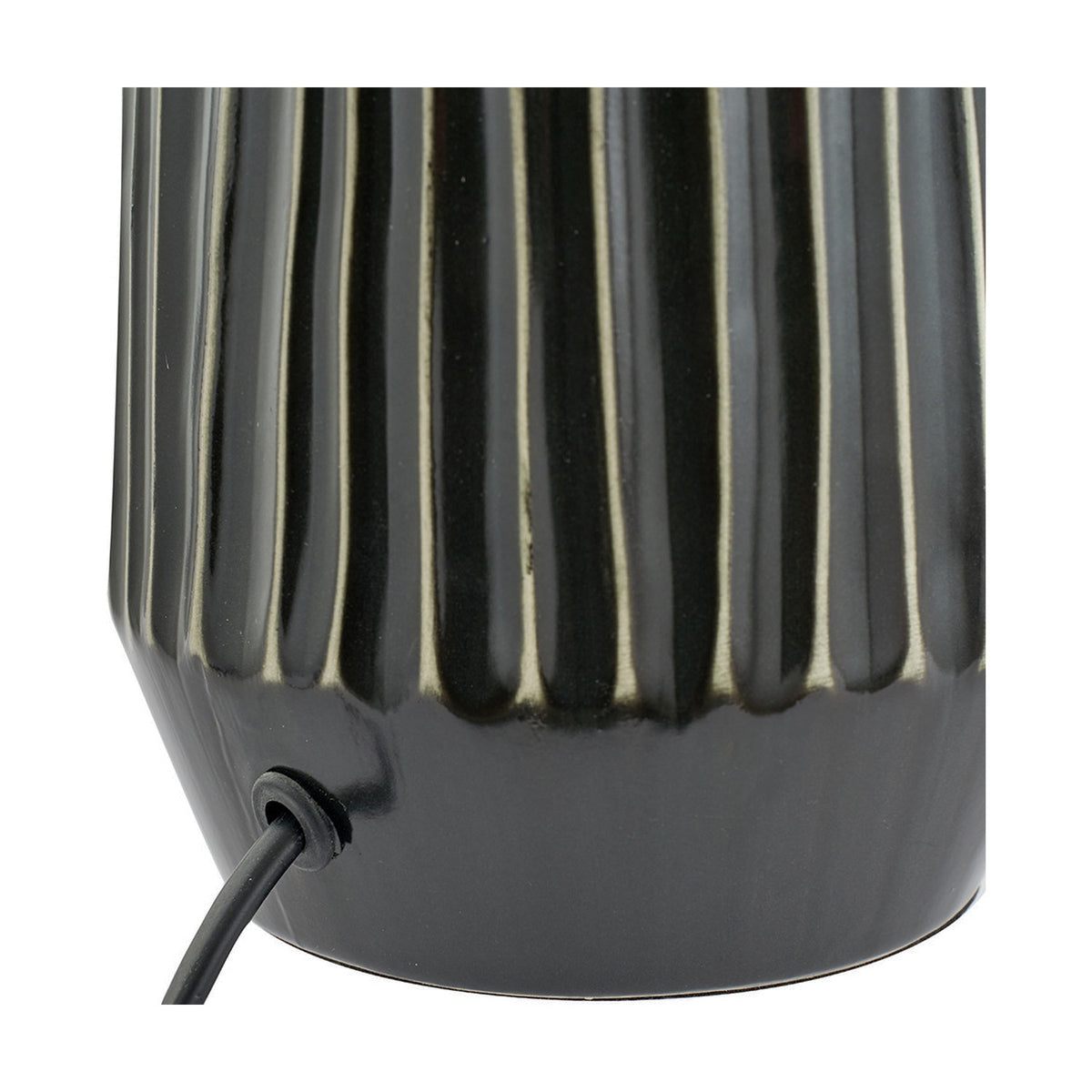 Close-up of the Artemis table lamp's black textured ceramic base, showing vertical ribbed detailing and the cable exit point on a plain background.