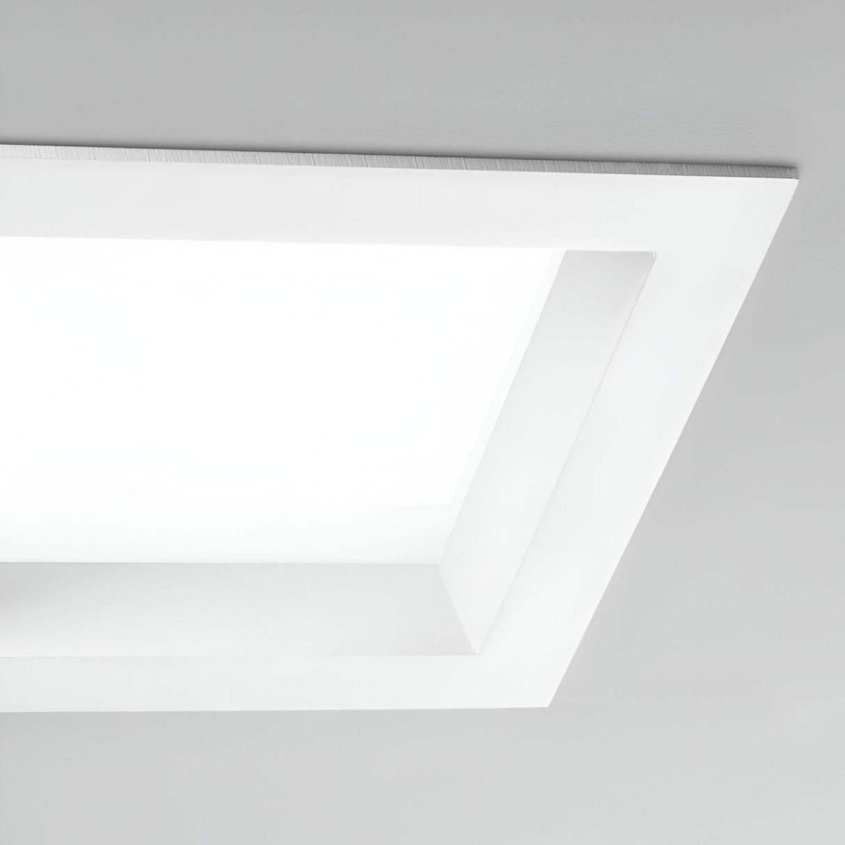 A contemporary and minimalistic ceiling fixture, the Radiara-2 Square LED Recessed Downlight boasts a large square shape with a sleek design, incorporating an LED bulb that emits bright 3000K white light, ideal for complementing a plain ceiling.