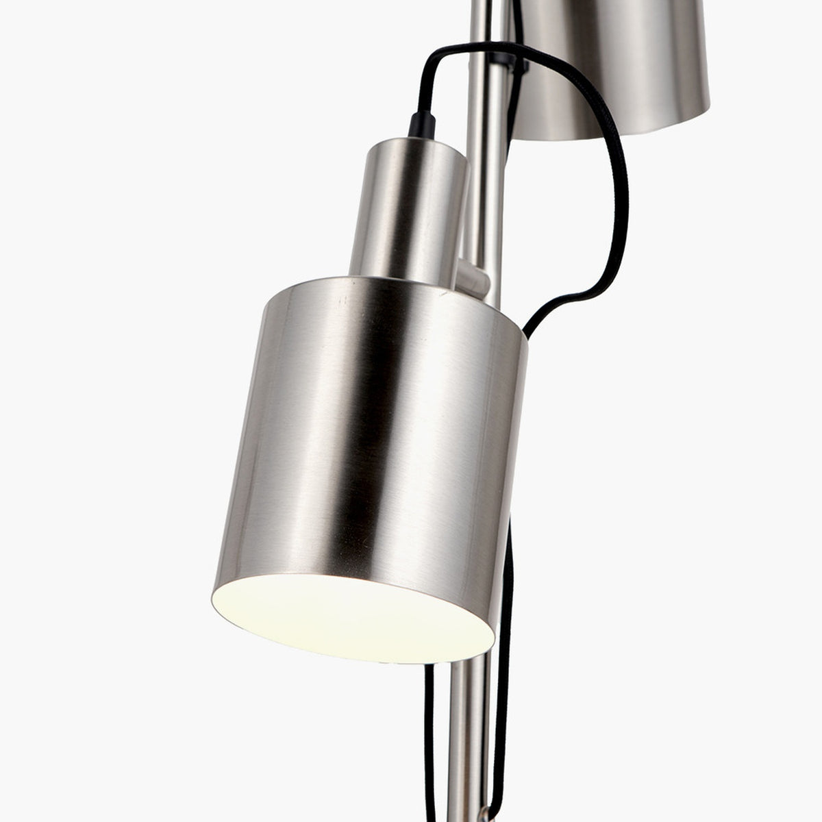 Close-up of the Aaron brushed chrome silver task floor lamp showing a cylindrical metal shade, black cable, and adjustable arm against a white background.