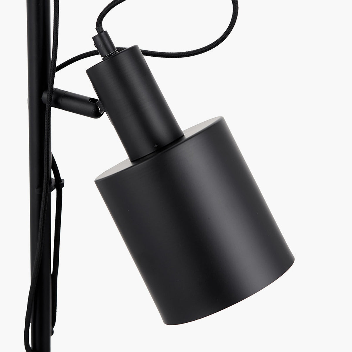 Close-up of the Aaron Black Iron Task Floor Lamp's cylindrical shade and adjustable joint in matte black metal, with fabric cable, against a plain white background.