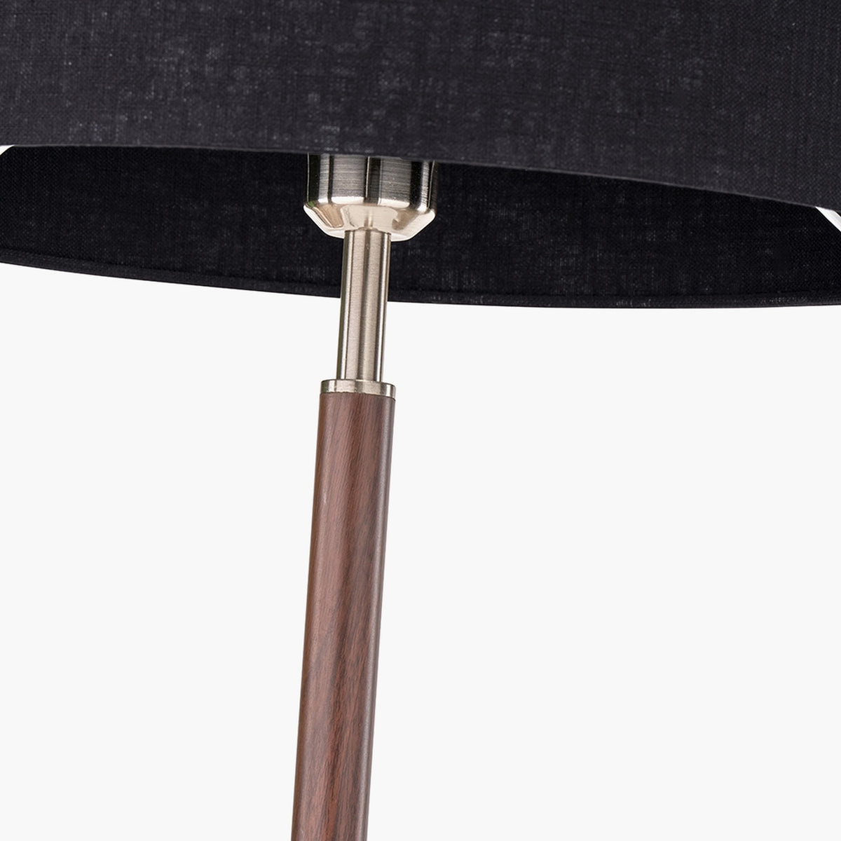 Close-up of the Gianni floor lamp's brushed silver neck joint linking a black linen shade to a wood-effect stem.