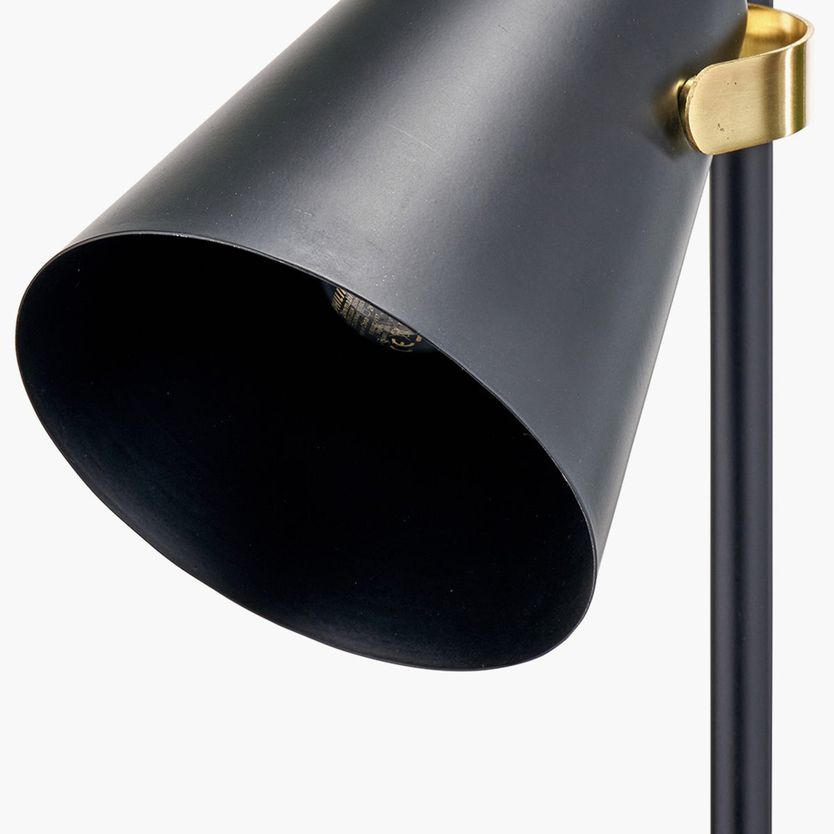 Close-up of the Theia Black & Brushed Brass Task Floor Lamp, showing a matte black conical metal shade with a brushed brass mounting bracket on a black pole.