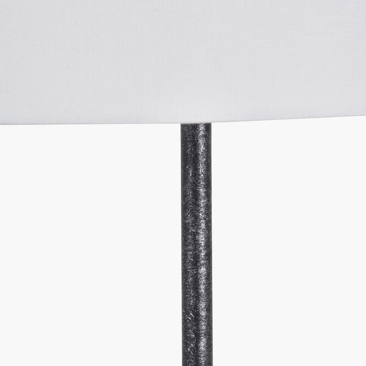 Close-up of the Vala Graphite Metal Textured Effect Ball Floor Lamp's textured grey metal stem beneath a white fabric shade, on a plain background.