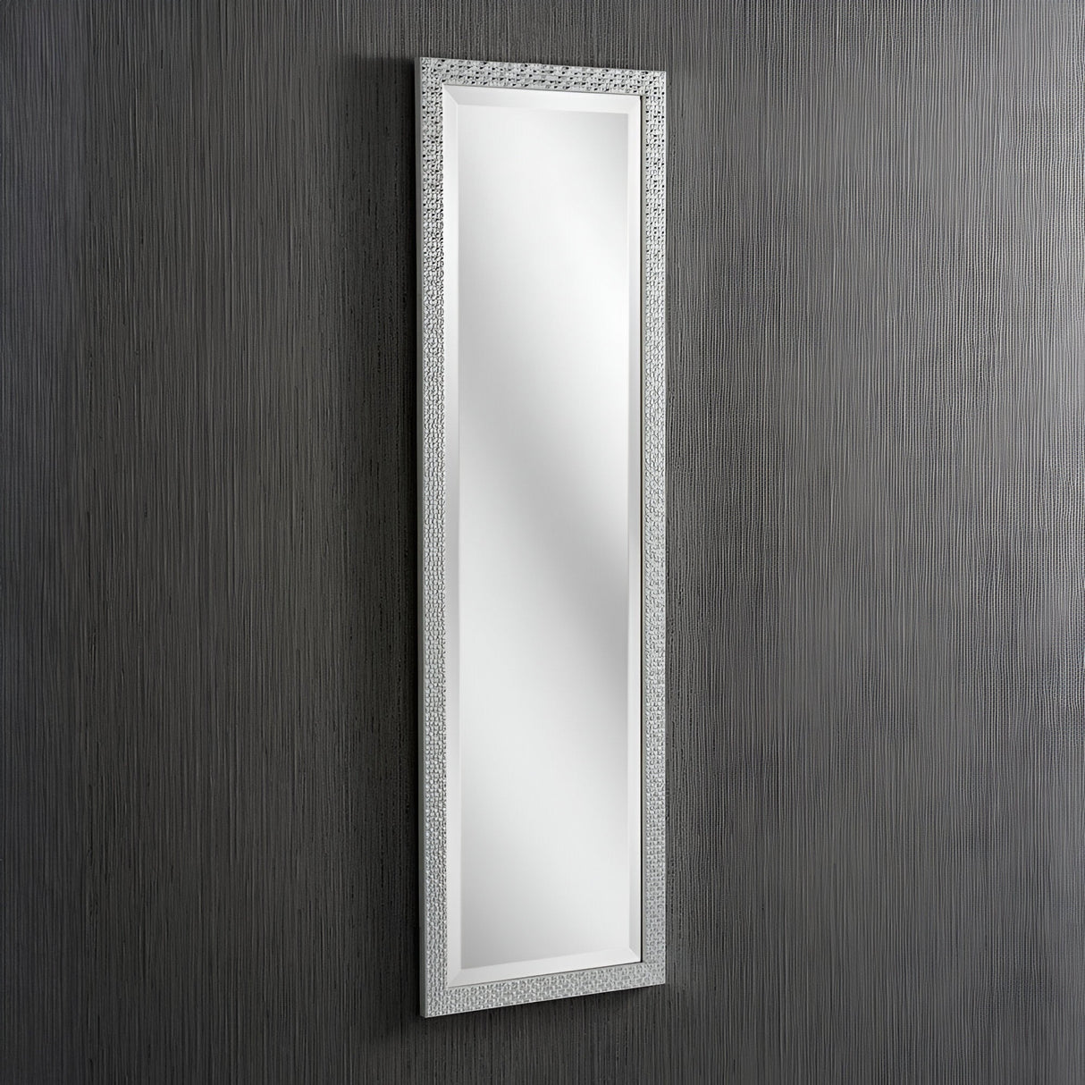 The Frost Rectangle Wall Mirror in silver hangs on a vertically striped gray wall, featuring a textured frame that adds an elegant touch to complement the minimalist design and modern luxury of the interior.