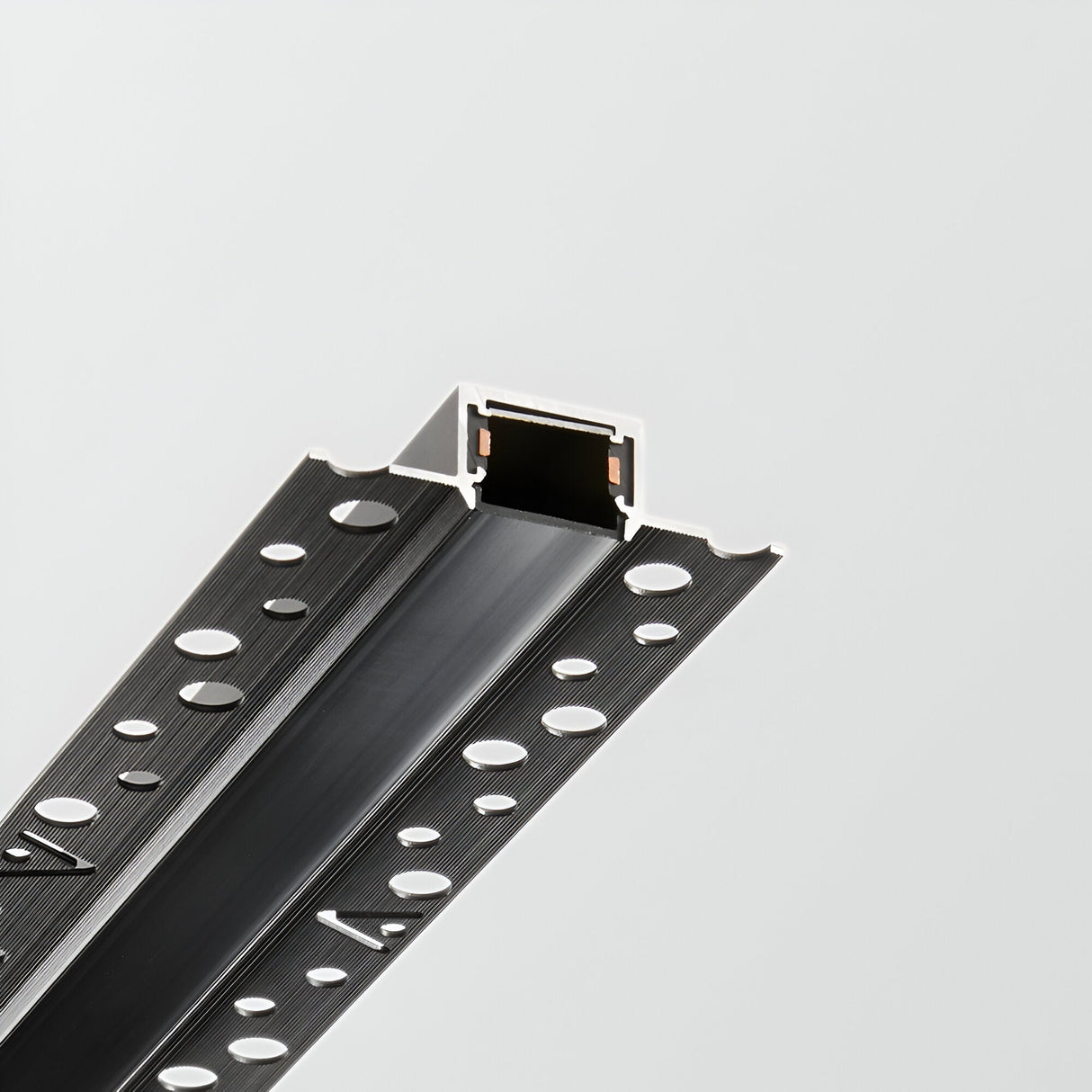 A close-up of the Viora Track Cover - Black, 1m in matte finish showcases its circular perforations along its length, set against a plain light gray background. The lighting track system's open end reveals a rectangular hollow interior.