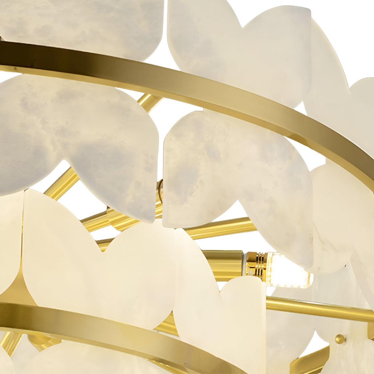 Close-up of the Petraia LED 4 Tier Floral Alabaster Chandelier in Brushed Brass & Soft White, featuring gold metal rings and petal-shaped alabaster panels surrounding an exposed light bulb.