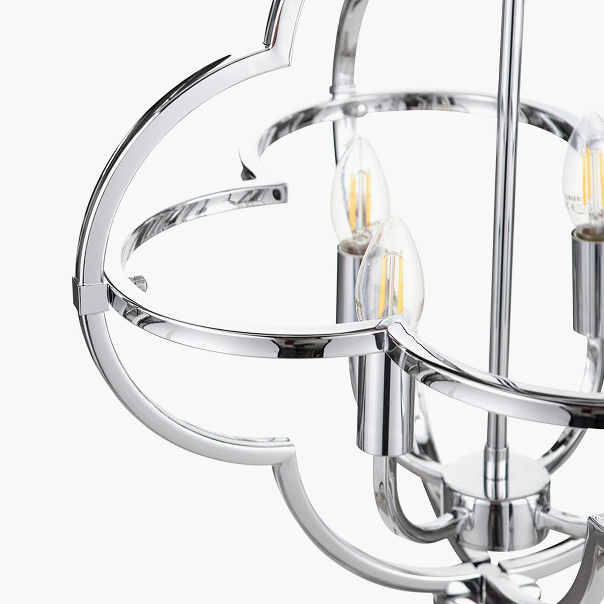Close-up of the Amine Chrome 4 Light Fleur De Lys Pendant, showing curved steel frame and candle-style bulbs in a polished chrome finish against a white background.