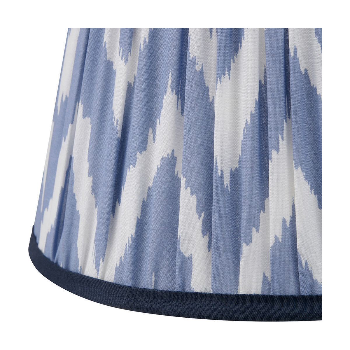 Close-up of the Kamilah Blue Chevron Pleated Tapered Lamp Shade, 25cm, showing pleated fabric in a blue and white chevron pattern with a navy trimmed edge.