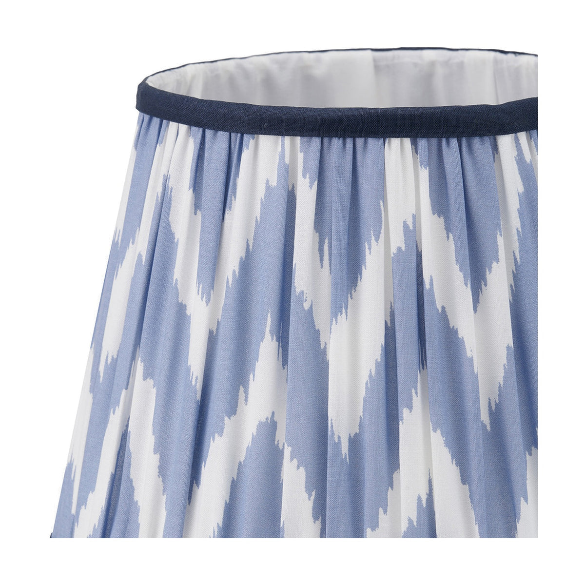Close-up of the Kamilah Blue Chevron Pleated Tapered Lamp Shade, 25cm, showing blue and white zigzag fabric with gathered pleats and a navy trim edge.