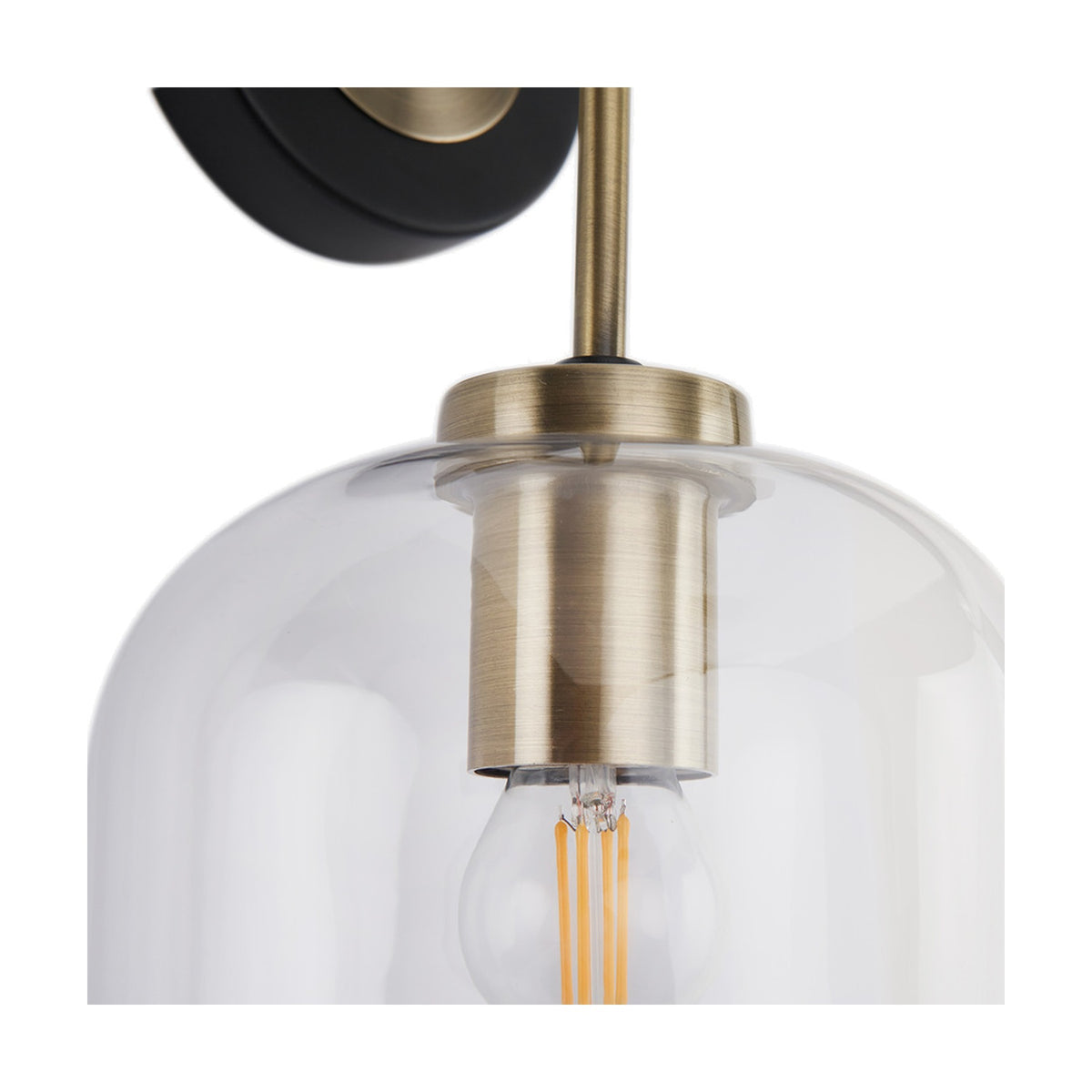 Close-up of the Florence Black Iron & Glass Wall Light showing the antique brass fitting, clear glass dome shade and exposed filament bulb, with black wall mount above.