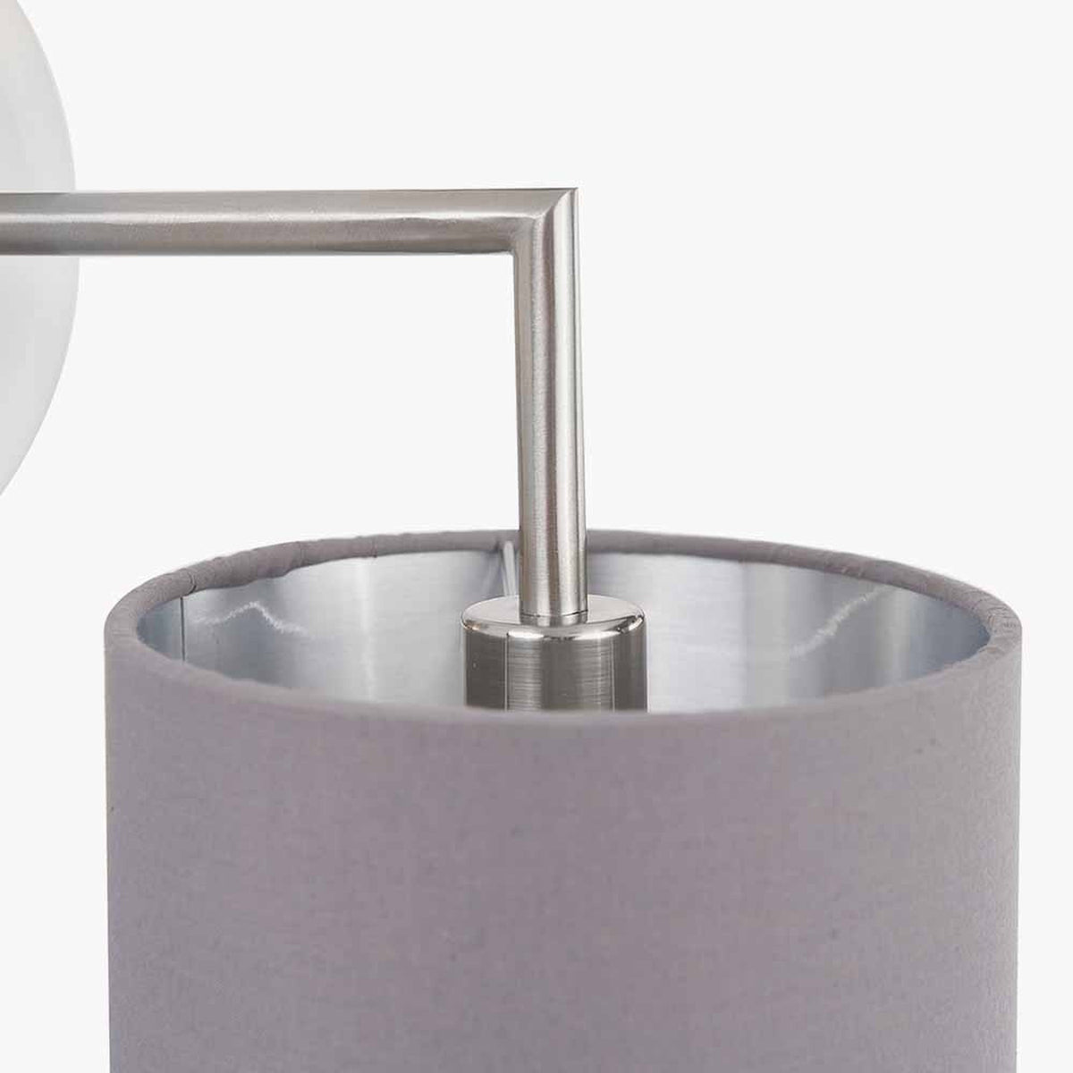 Close-up of the Elin Brushed Silver & Steel Grey Wall Light showing the angular metal arm meeting a cylindrical steel grey fabric shade with brushed silver interior.