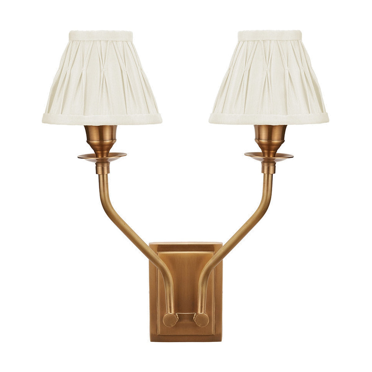 Tatiana antique brass double wall light with two upward-curving arms and pleated cream silk mix shades, shown on a plain white background.