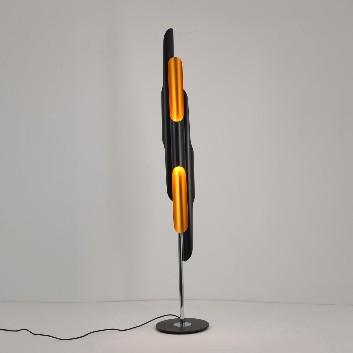The Stealth 6 Light Floor Lamp - Brass & Black features a tall, modern design with brass and black panels on a round black base—an eye-catching sculptural piece perfect for contemporary spaces.