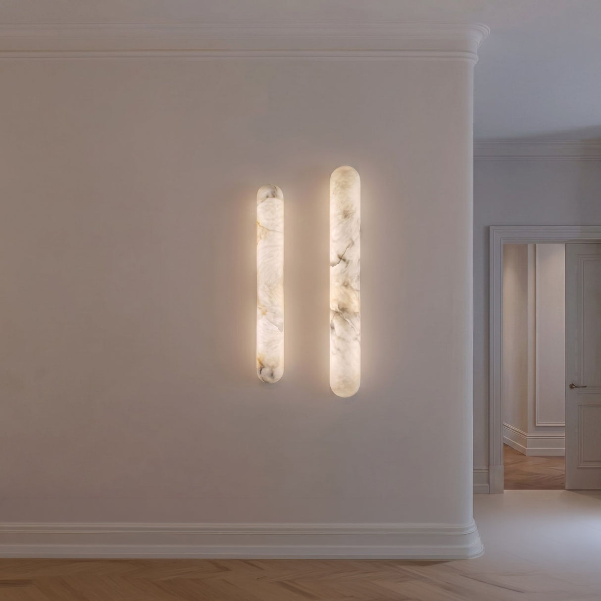 Arvella Small Alabaster Column Wall Light in soft white, paired vertical alabaster cylinders glowing warm white on a hallway wall.