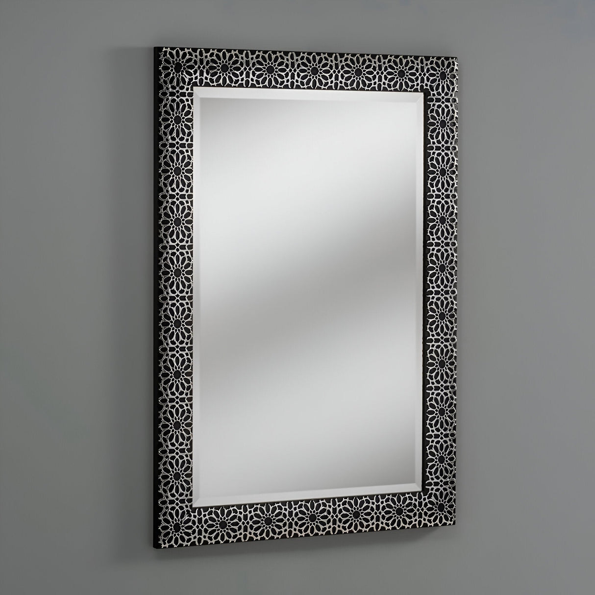 The Prism Rectangle Wall Mirror Black - 107x74cm is set against a simple gray backdrop, highlighting its elaborate black frame decorated with a geometric pattern. This mirror features a modern design, presenting an elegant and pristine reflective surface.
