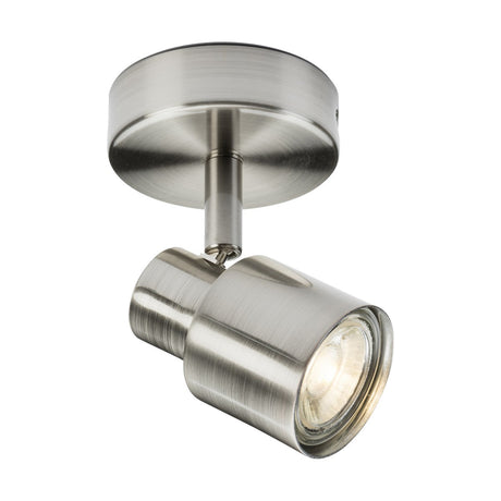 The Single Spotlight - Brushed Chrome is mounted on a circular base and features a GU10 cylindrical light fixture with an adjustable directional head, currently angled downward. Its modern, minimalistic design includes one bulb for targeted lighting.