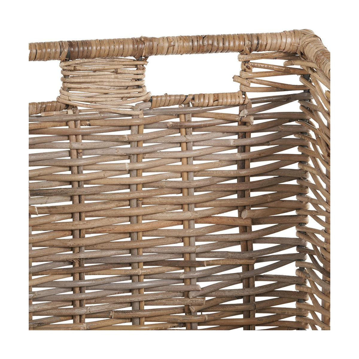Close-up of a Tobs Kubu rattan log basket in grey, showing woven rattan sides and a wrapped rim with cut-out handles, on a white background.