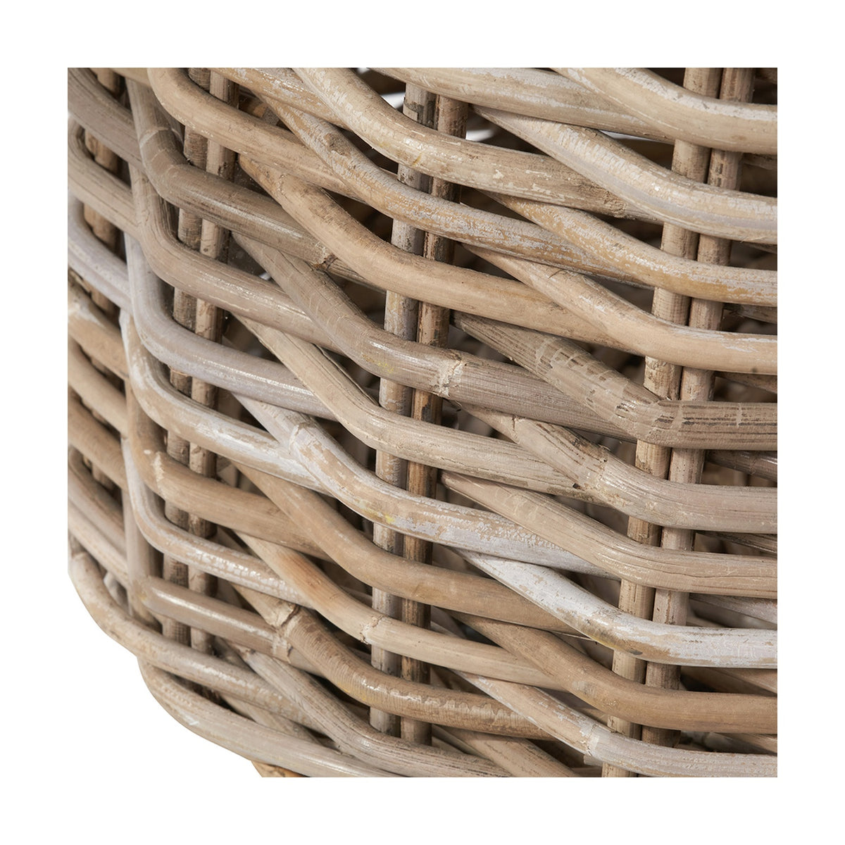 Close-up of the Tobs grey rattan round log basket, showing tightly woven wicker texture with a whitewashed finish over natural wood tones.