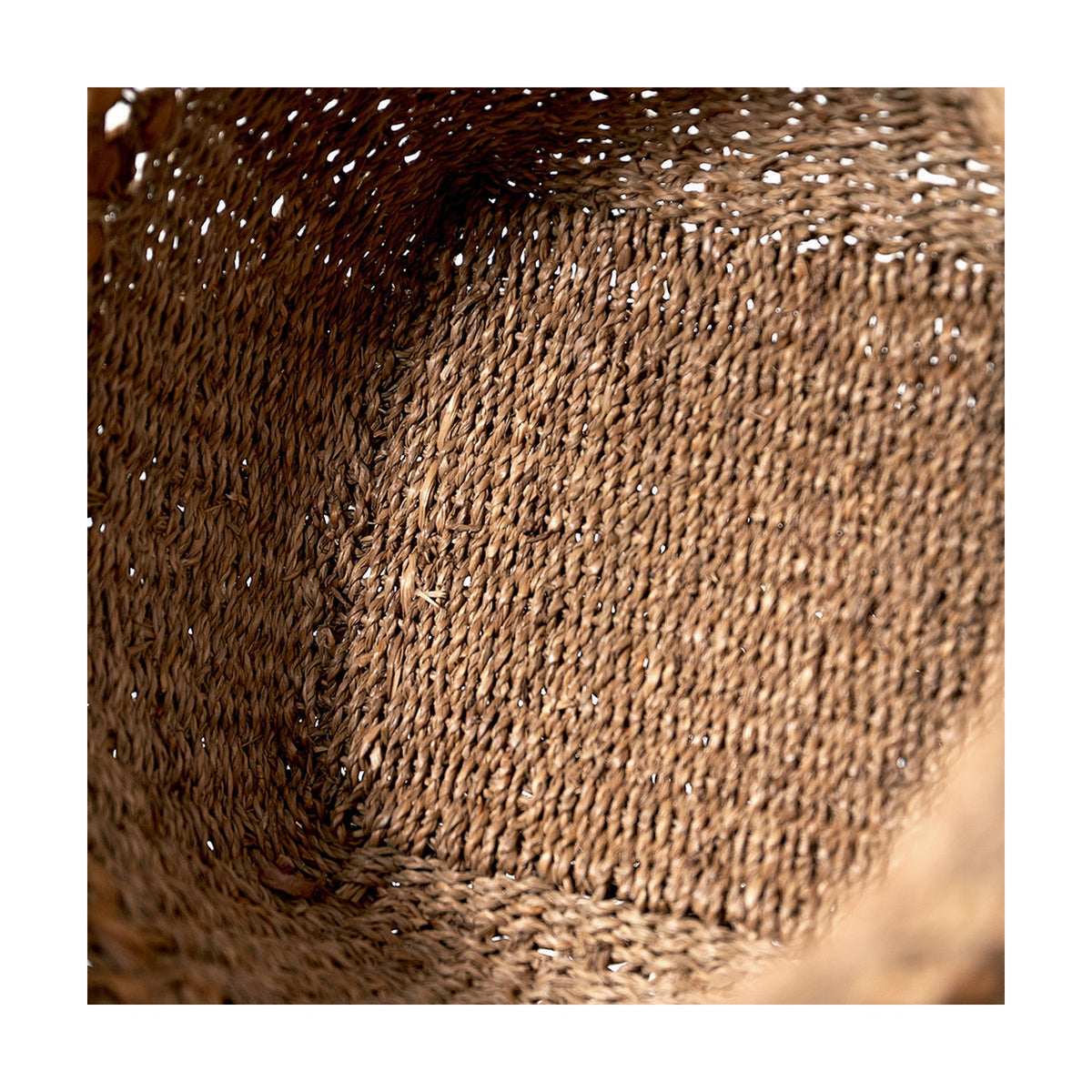 Close-up interior view of a natural seagrass and water hyacinth tall basket, showing tightly woven texture in earthy brown tones, from the set of 3, 43cm.