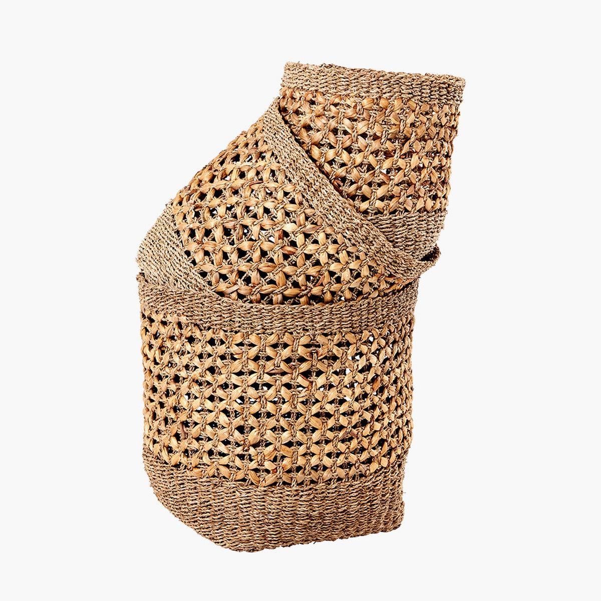 Nested set of tall round storage baskets in natural seagrass and water hyacinth with an open weave pattern, shown tilted against a plain white background.