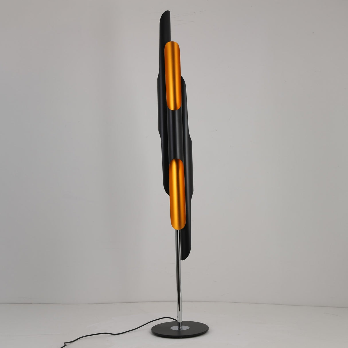 The Stealth 6 Light Floor Lamp in brass and black features cylindrical elements on a slim chrome stand with a round base, presented against a plain white background.