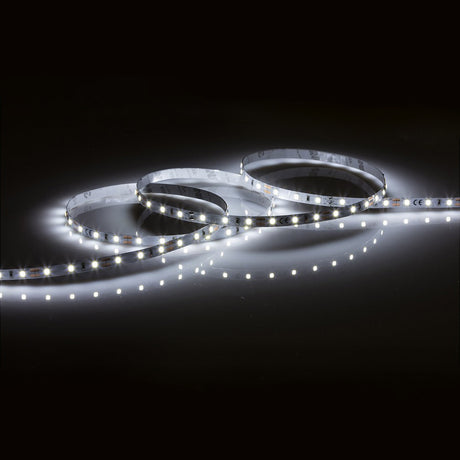A 12V 4.8W LED Strip Light with a color temperature of 6000K is coiled in three loops on a dark surface, casting soft reflections with its bright white diodes. The daylight LED lighting creates an illuminated path, emphasizing the strip's flexibility and contemporary design.