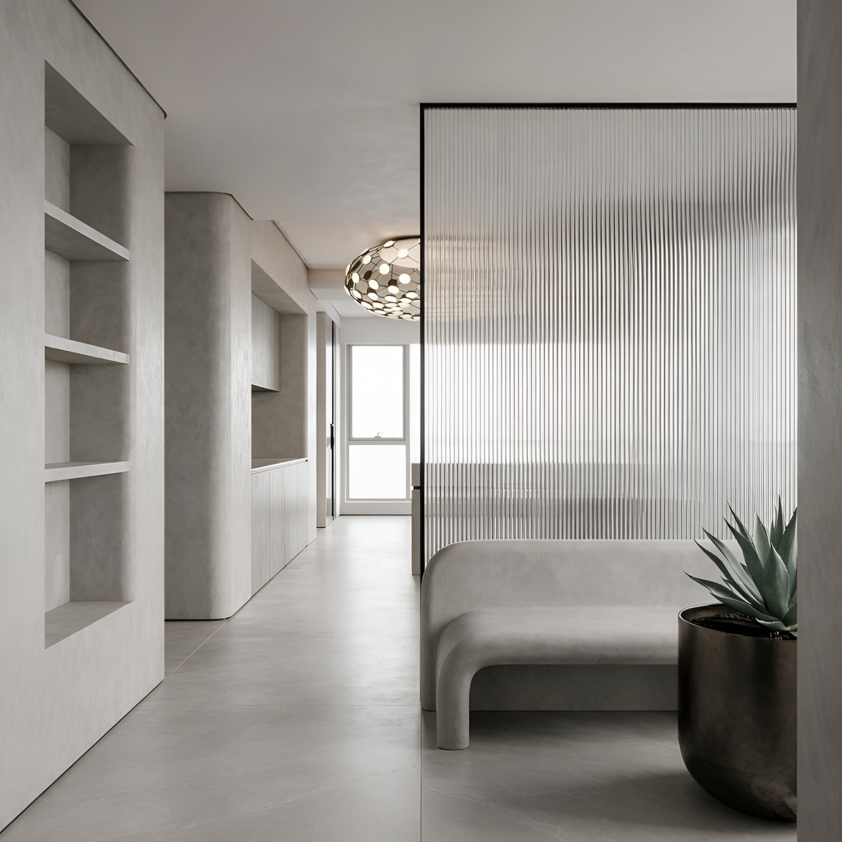 Minimalist interior with light gray walls and floor, built-in shelves, a curved bench, potted plant, ribbed glass partition, and natural light from a window. The Mesh LED Flush Ceiling Light - Black adds an elegant contemporary touch to the space.