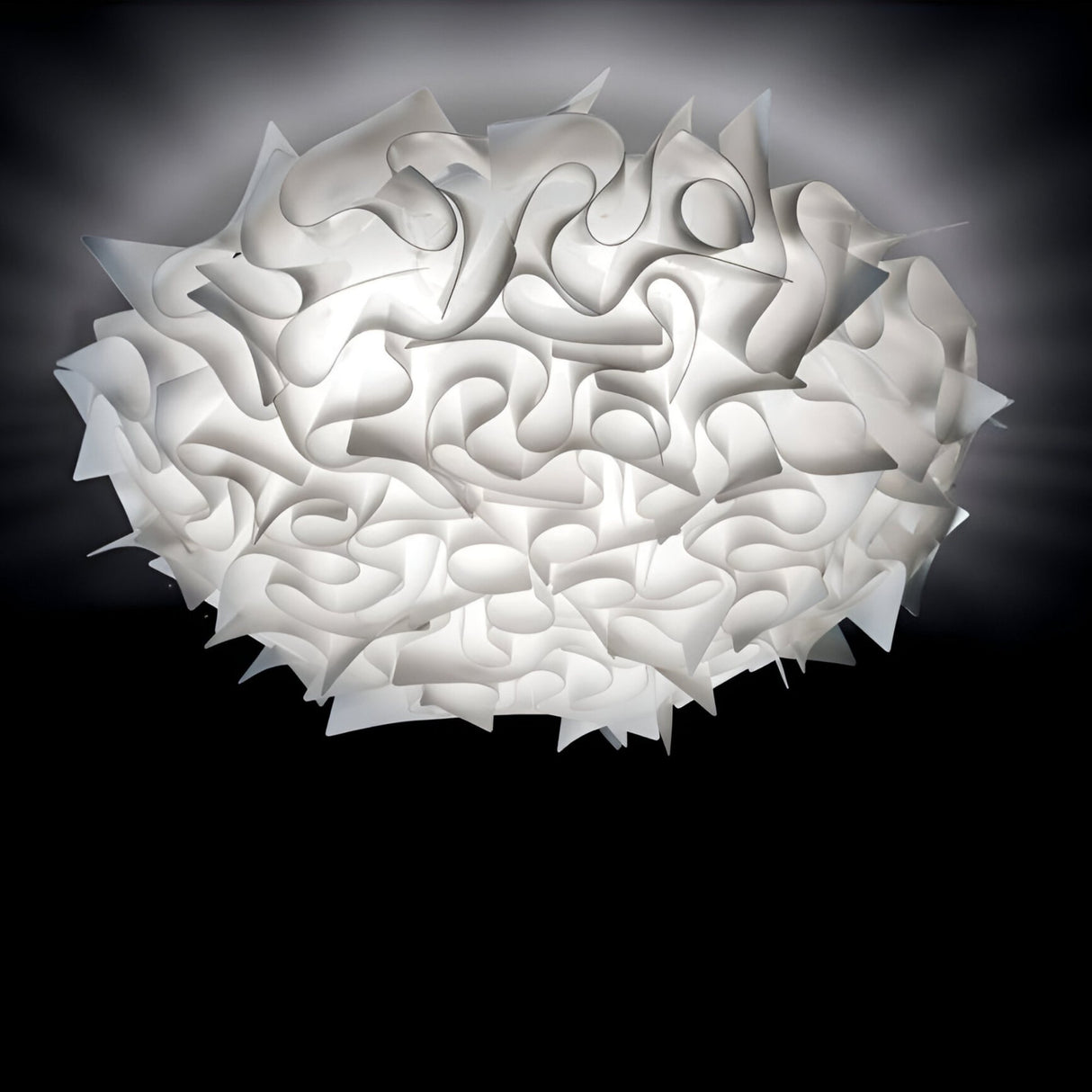 The Violla 3 Light Flush Ceiling Light in white features an abstract, sculptural design with interlocking panels that create a cloud-like look, casting diffused light and gentle shadows across your ceiling.