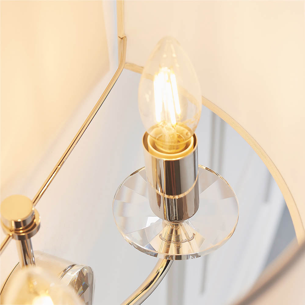 Close-up of the Castdon 2 Light Wall Light in nickel, showing a candle-style bulb on a plated arm with a faceted crystal base, beneath a white shade.