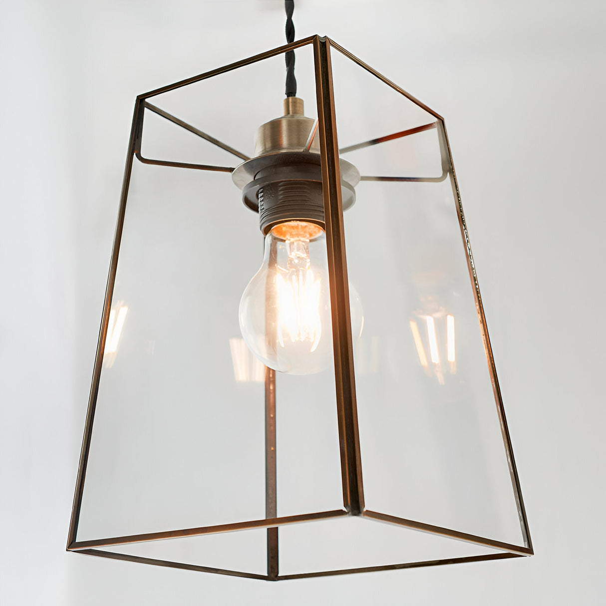 Endon Aldwell pendant light with angular clear glass panels, antique brass trim, and a single E27 filament bulb, shown against a plain light background.
