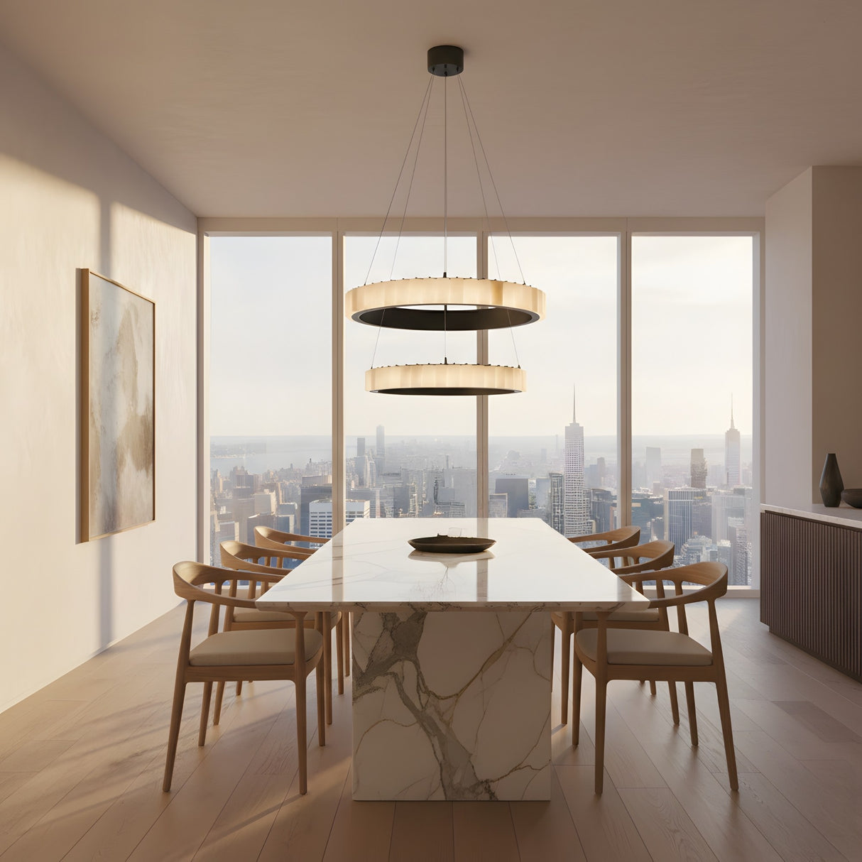 A modern dining room featuring a marble table, wooden chairs, city skyline views, minimalist decor, and the Lucenza LED 2 Tier Halo Ring Alabaster Chandelier in Matte Black & Soft White above the table.