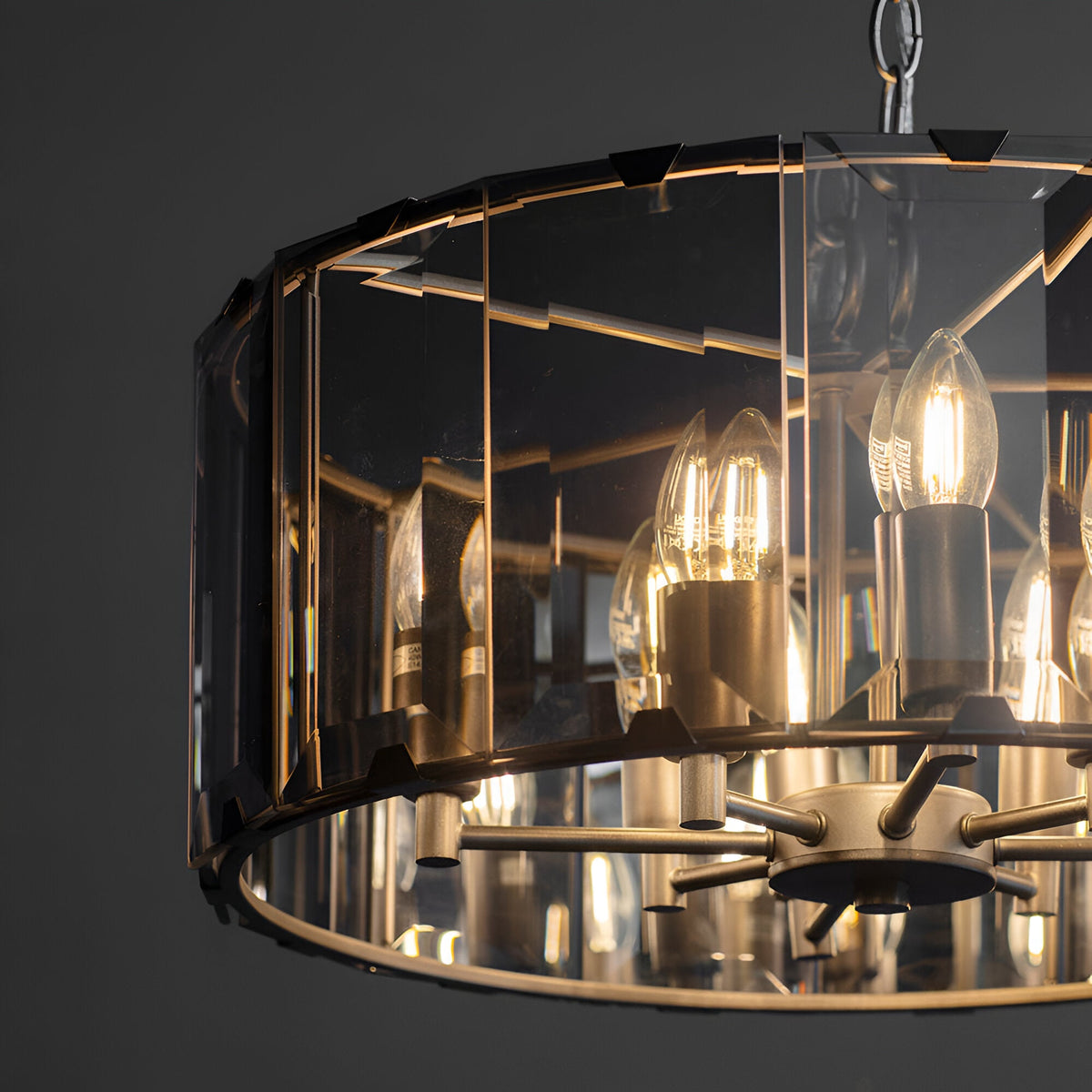 Close-up of Endon Bevshaw 8 light pendant showing bevelled smoke glass panels, slate grey frame, and lit E14 candle bulbs on a dark background.