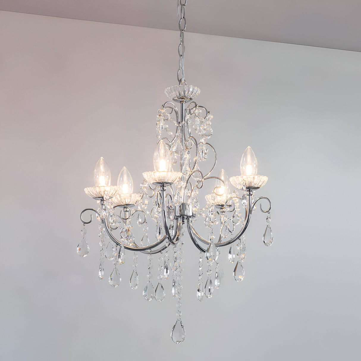 Endon Crandon 5 light bathroom chandelier in polished chrome with clear faceted crystal droplets, suspended from a chain against a light ceiling.
