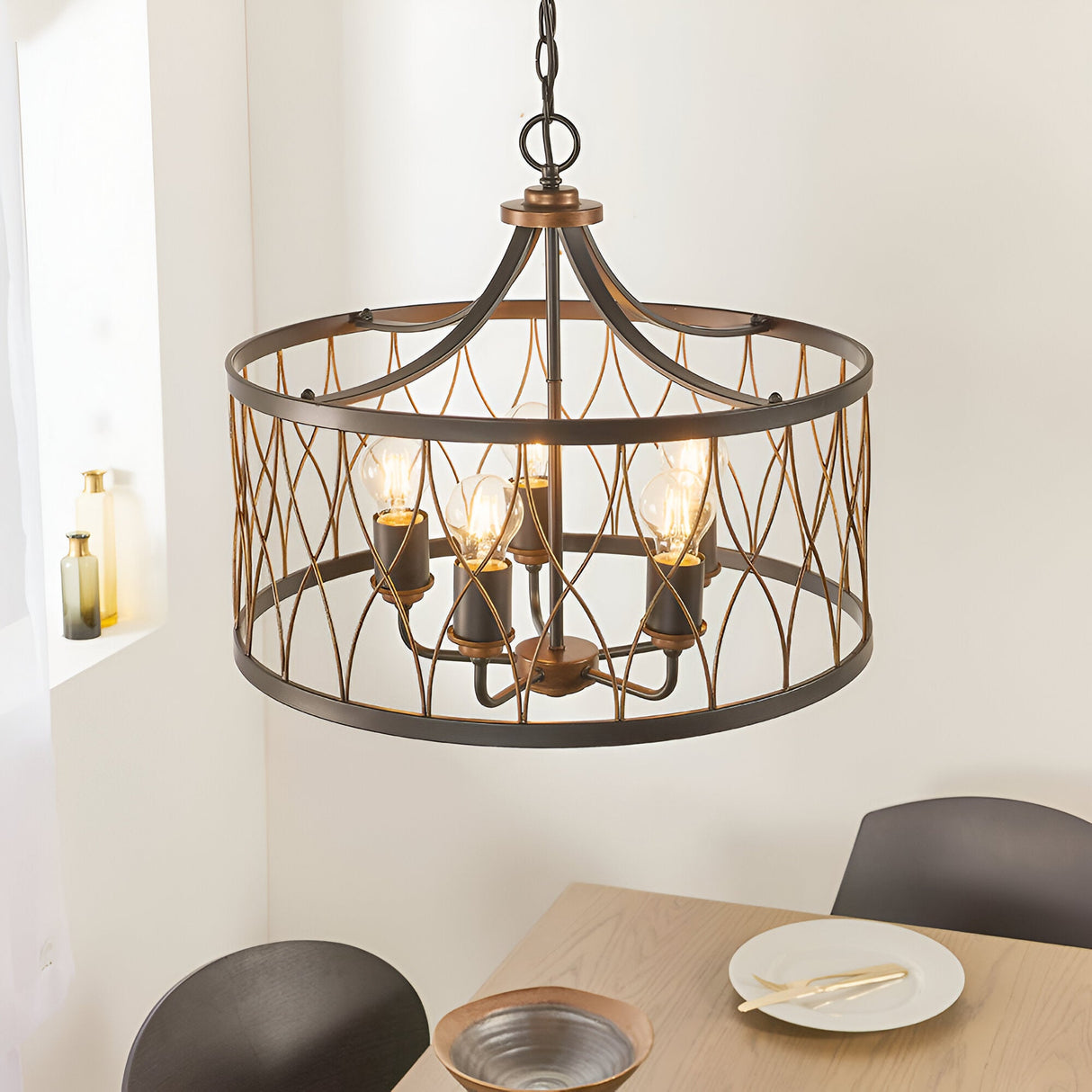 Hulton 5 Light Pendant in bronze and black with open lattice metalwork and five exposed bulbs, hung above a dining table on an adjustable chain.