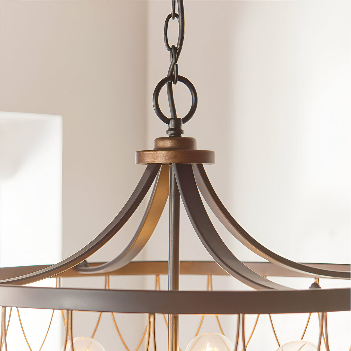 Hulton 5 Light Pendant close-up showing black metal chain, bronze canopy and curved black arms above a lattice cage frame.