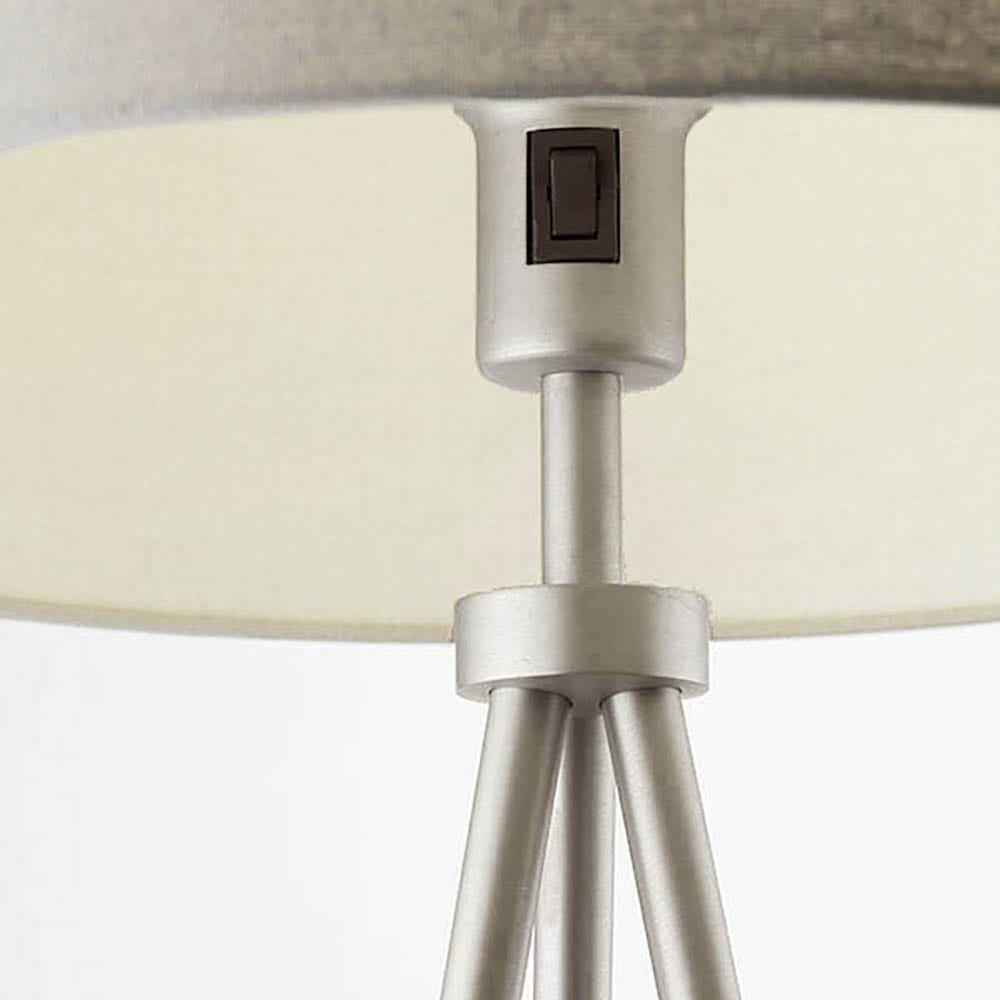 Close-up of the Endon Cranwell Floor Lamp's nickel lampholder with rocker switch beneath a grey linen-effect drum shade, above splayed tripod legs.