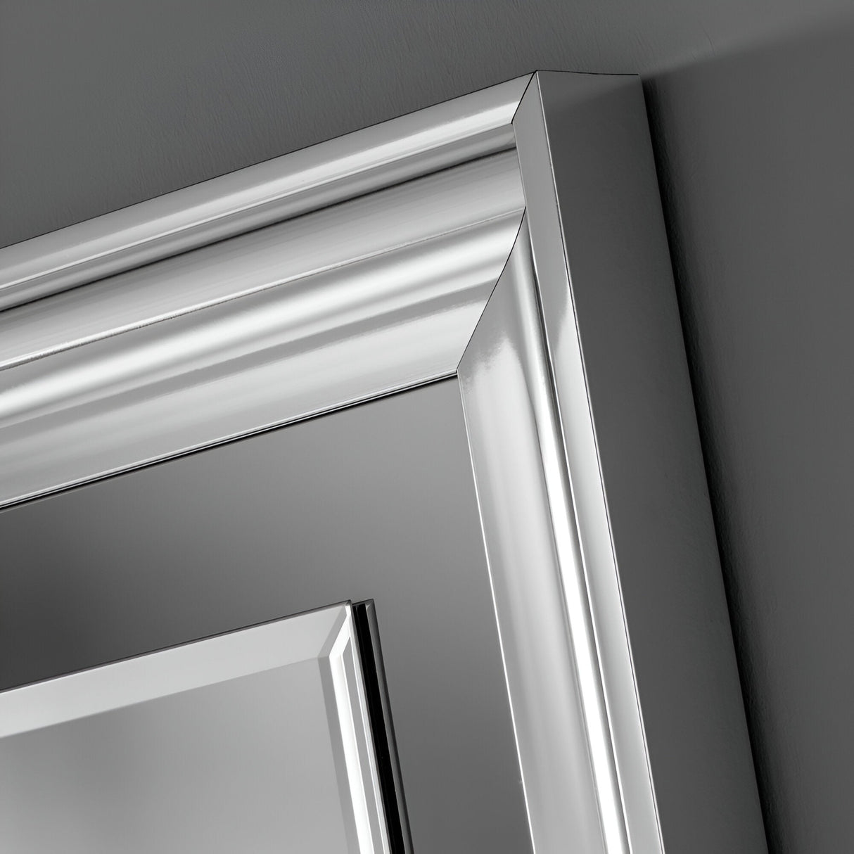 Close-up of the Wave Rectangle Wall Mirror, showcasing its sleek and modern design with a silver lacquered finish and glossy texture. The mirror features clean lines and a reflective surface, mounted against a gray wall, capturing the essence of contemporary design akin to luxury door frames.