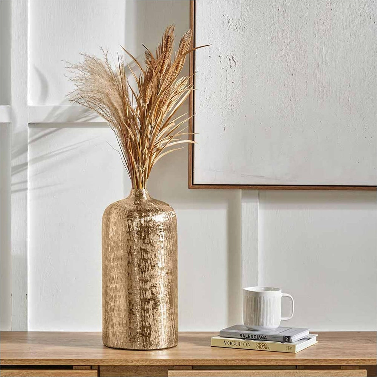 Gold Aluminium Hammered Vase, 38cm, with dried pampas grass and wheat stems, styled on a wooden sideboard beside books and a mug.
